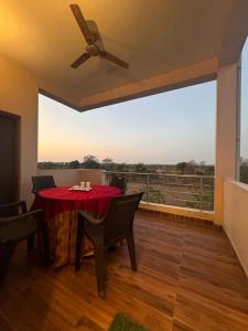 een eetkamer met een rode tafel en een groot raam bij Silver Green Resort in Gumgaon