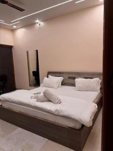 een slaapkamer met een groot bed met witte lakens bij Silver Green Resort in Gumgaon +1 foto