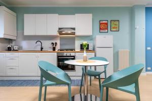 een keuken met witte kasten en een tafel en stoelen bij Cozy apartment in Castelfranco Veneto