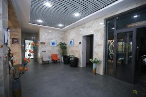 eine Lobby mit einem Wartebereich mit orangefarbenen Stühlen in der Unterkunft Ziyorat Luxury Hotel in Fargʻona + 34 Fotos