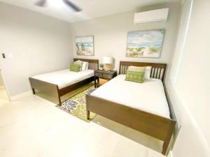 a bedroom with two beds and a table with a lamp at Villa Kismet - Beachfront community with 3 pools in Brenas