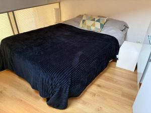 a bedroom with a bed with a black blanket at Charmant T2 en duplex in Bordeaux