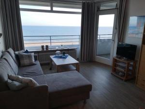 un soggiorno con divano e vista sull'oceano di Strandhotel Wohnung 61 a Dahme