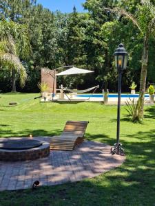 una panchina e un lampione accanto a un palo della luce di Los horneros a General Rodríguez