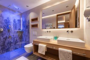 un bagno con due lavandini e una doccia di Apart La Vita a Sankt Anton am Arlberg Altre 67 foto