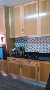 a kitchen with wooden cabinets and black counter tops at Get house kira in Cidade Velha