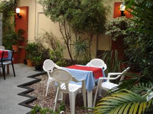 una mesa y sillas en un jardín con mesa y sillas rojas en Hotel Esperia en Buenos Aires