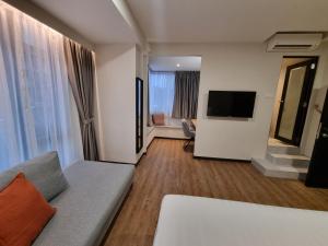 ein Wohnzimmer mit Sofa und Flachbildfernseher in der Unterkunft Miico Hotel Permas Jaya in Johor Bahru