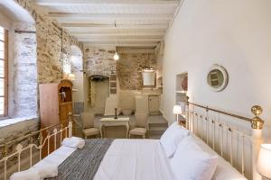 a bedroom with a bed and a table and chairs at Hermia Mansion in Ermoupoli