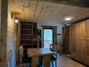 een eetkamer met een houten tafel en stoelen bij Baita Mot in Marmora