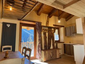 een keuken met een tafel en een groot raam bij Baita Mot in Marmora