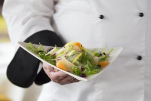 a person is holding a plate of food at The Fernery Lodge & Spa in Stormsrivier