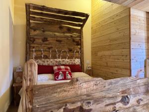 een slaapkamer met een houten bed met rode kussens erop bij Baita Mot in Marmora +29 foto's