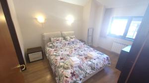 una camera da letto con un letto con copriletto floreale di Borovets Apartments, Flora Violet Residence a Borovets