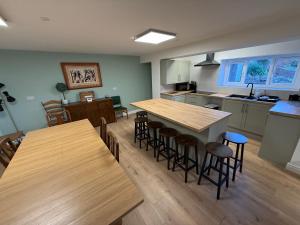 a kitchen with wooden tables and bar stools at New 4 Bed House Sleeps up to 8 People in Chepstow