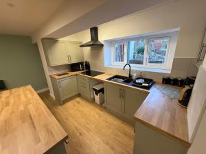 a kitchen with white cabinets and a sink and a window at New 4 Bed House Sleeps up to 8 People in Chepstow +8 photos