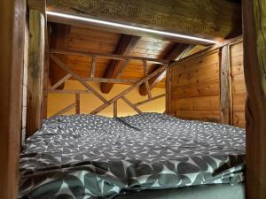 een bed in een kamer met een houten plafond bij Baita Mot in Marmora
