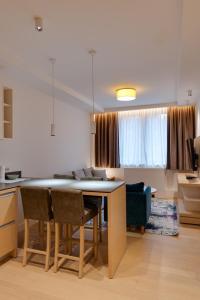 Una cocina y una sala de estar con mesa y sillas. en Apartmani Zepterme by CENTRAL, en Vrnjačka Banja 279 fotos más