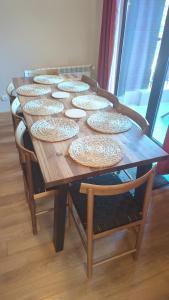 un tavolo in legno con piatti sopra di Borovets Apartments, Flora Violet Residence a Borovets Altre 13 foto