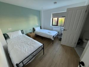 a small bedroom with two beds and a window at New 4 Bed House Sleeps up to 8 People in Chepstow