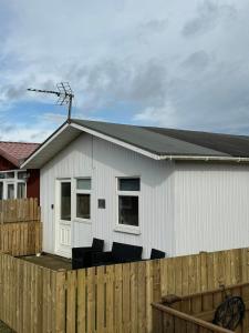 a white house with chairs in front of a fence at Sandcastle Chalet in Bridlington