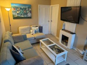 a living room with a couch and a tv at Sandcastle Chalet in Bridlington