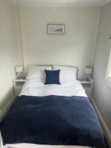 a bedroom with a bed with a blue pillow on it at Sandcastle Chalet in Bridlington