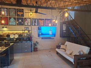 un soggiorno con un divano e una TV a parete di Los horneros a General Rodríguez