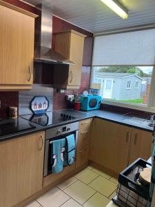 a kitchen with a stove and a sink and a window at Sandcastle Chalet in Bridlington