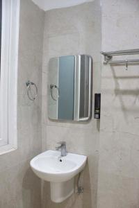 ein Badezimmer mit Waschbecken und Spiegel an der Wand in der Unterkunft JSB Hotel in Faridabad + 58 Fotos