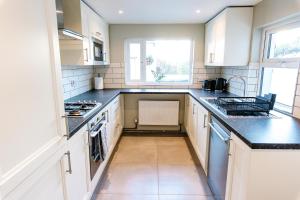 a kitchen with white cabinets and black counter tops at The Nines in Bangor