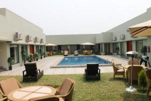a courtyard with chairs and a swimming pool at Hotel Moon Palace Kolwezi in Kolwezi
