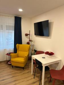 a living room with a yellow chair and a table at Apartmani Bjelovar in Bjelovar