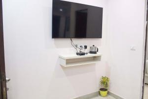 eine weiße Wand mit einem TV an der Wand in der Unterkunft JSB Hotel in Faridabad