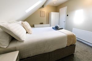 a bedroom with a large bed with white pillows at The Nines in Bangor