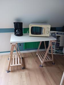 een witte tafel met een magnetron erop bij Lila in Souillé