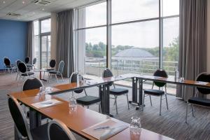 uma sala de conferências com mesas e cadeiras e janelas grandes em Best Western Hotel Sourcéo em Saint-Paul-lès-Dax mais 71 fotografias