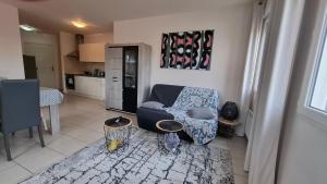 ein Wohnzimmer mit einem Stuhl und eine Küche in der Unterkunft Apppartement 2 pièces centre-ville in Chauffailles