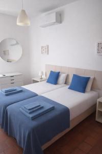 Dos camas en una habitación con almohadas azules. en Oura Family House, en Albufeira 15 fotos más
