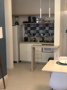 une cuisine avec des armoires blanches et un four à plaques de cuisson dans l'établissement Baltico302, à Capão da Canoa