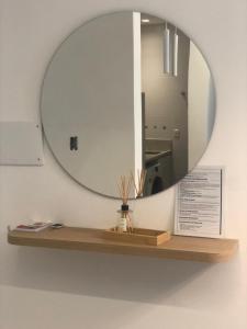 a mirror on a wall with a wooden shelf at Baltico302 in Capão da Canoa +14 photos