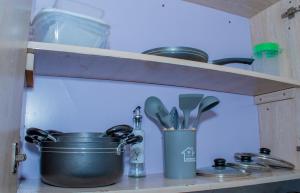 a kitchen shelf with a pot and utensils at Delsy Stays in Ruaka