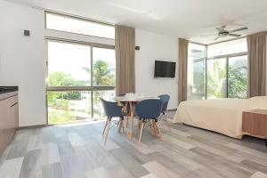 a bedroom with a bed and a table and chairs at Hotel Piedra del Caribe Puerto Morelos in Puerto Morelos