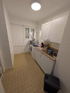 a small kitchen with white cabinets and a sink at Le petit casino in Menton