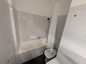 a white bathroom with a toilet and a bath tub at Le petit casino in Menton