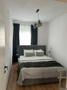 a bedroom with a large bed and a window at Apartmani Bjelovar in Bjelovar