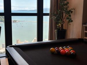 een pooltafel met ballen voor een raam bij Vista Mar - Suíte, Cozinha Completa, Até 4 pessoas in Itapema