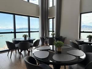 een restaurant met tafels en stoelen en grote ramen bij Vista Mar - Suíte, Cozinha Completa, Até 4 pessoas in Itapema