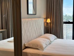 een hotelkamer met een bed en een raam bij Vista Mar - Suíte, Cozinha Completa, Até 4 pessoas in Itapema