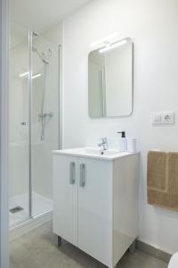 a white bathroom with a sink and a mirror at Residencia Universitaria Trinitarios in Valencia